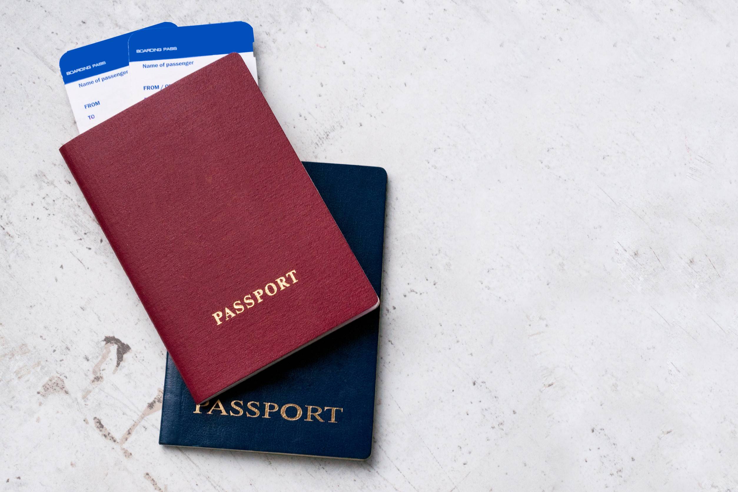 Two Travelers Passports Red And Blue With Boarding Passes